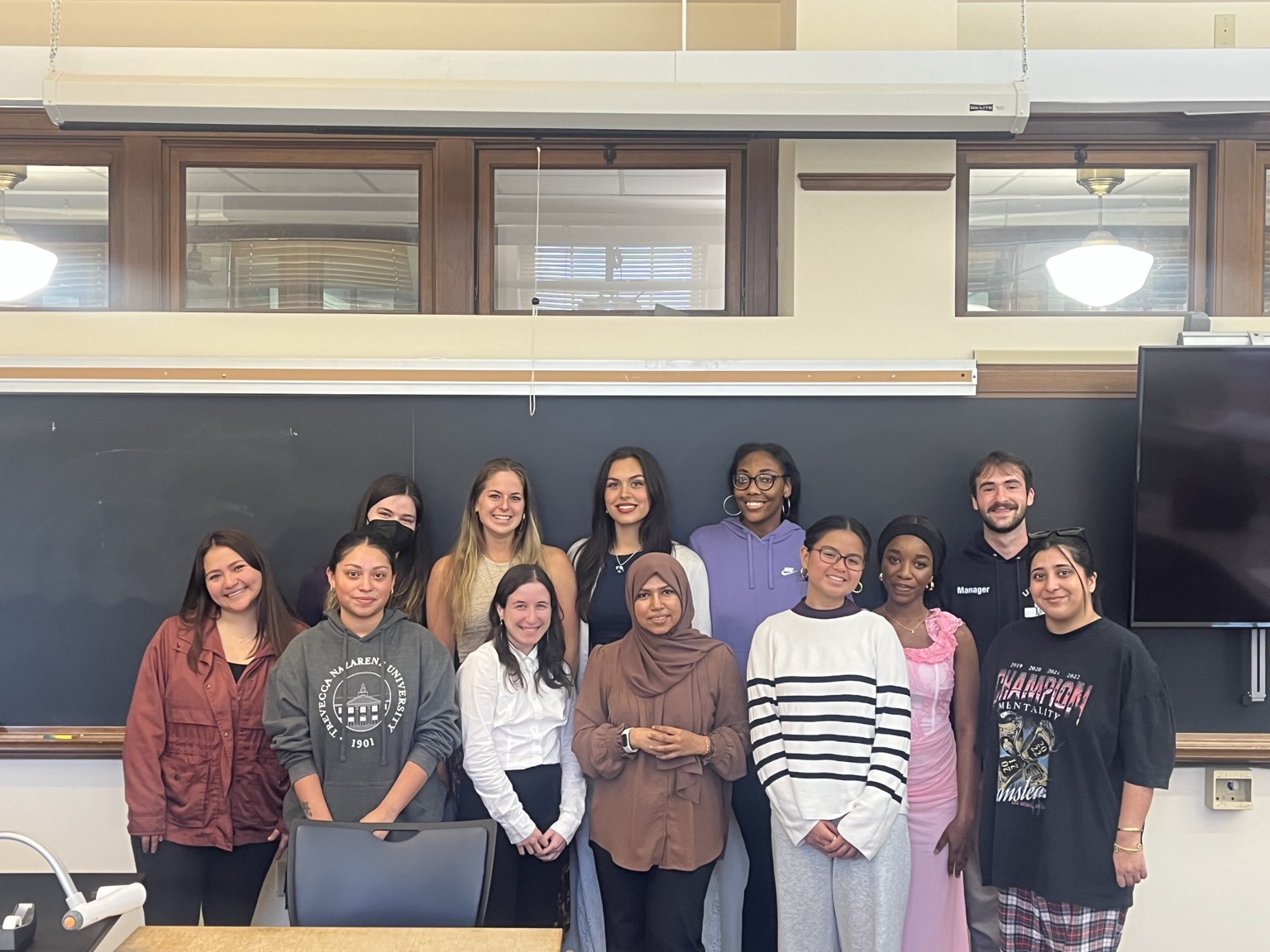 A class group standing in front of a blackboard.