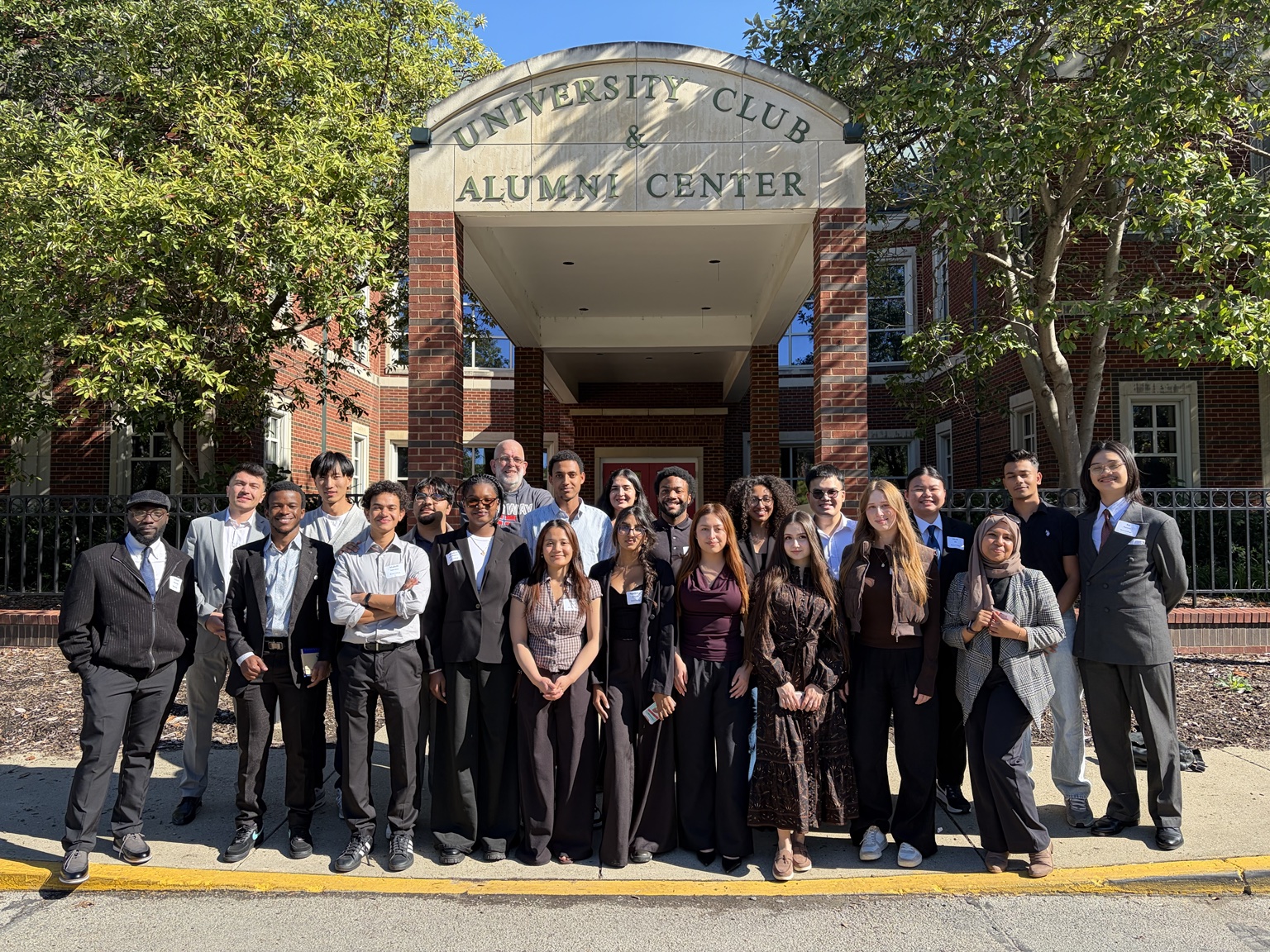 Students and colleagues standing outside the University Club and Alumni Center.
